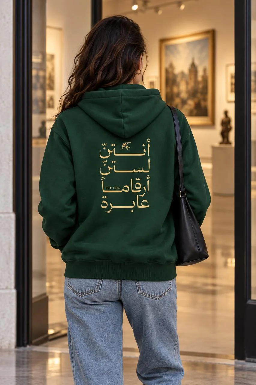 Model wearing the Forest Green Centenary Hoodie, showing the gold calligraphy on the back